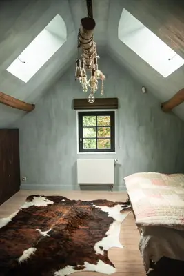 a bedroom with a bed and a chandelier at La Petite Foret Cottage in Brussels Countryside in Asse