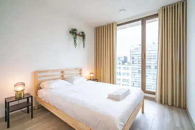 a bedroom with a large bed and a large window at Opera Apartments in the Center of Antwerp in Antwerp