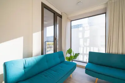 a living room with a blue couch and a window at Opera Apartments in the Center of Antwerp in Antwerp