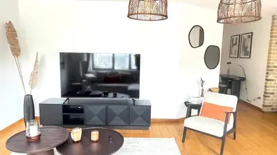 a living room with a table and a tv at Friends & Family Brussels Atomium 6-8 pers in Grimbergen