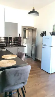 a kitchen with a table and a refrigerator at ailes Center 1 in Brussels
