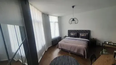a bedroom with a bed and some windows at ailes Center 1 in Brussels