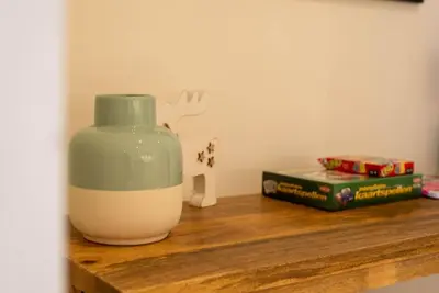 a vase sitting on top of a wooden shelf at Casa Matti - Modern Apartment with Canal View and Terrace in Ghent