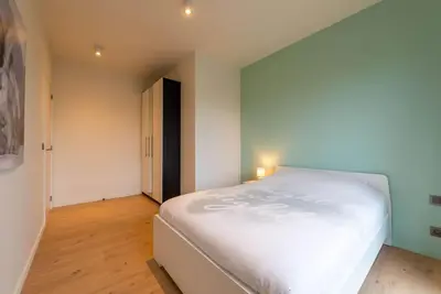 a bedroom with a large white bed in a room at Casa Matti - Modern Apartment with Canal View and Terrace in Ghent