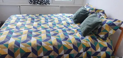a bed with a colorful quilt and pillows on it at Lovely room in Mortsel