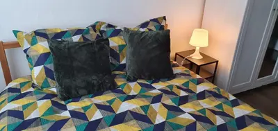 a bedroom with a bed with pillows and a lamp at Lovely room in Mortsel