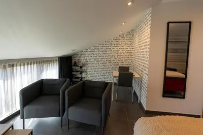 a living room with two chairs and a table at B&B De Vlierbeek in Sint-Niklaas