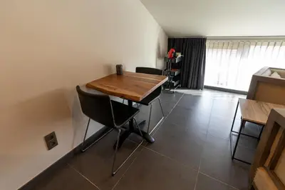 a dining room with a wooden table and chairs at B&B De Vlierbeek in Sint-Niklaas