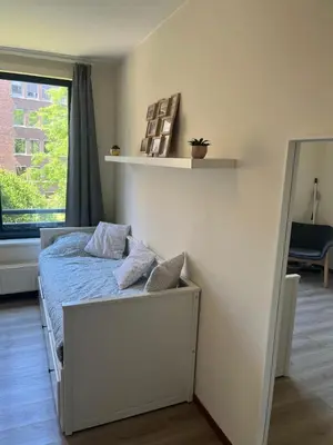 a bedroom with a bed and a mirror and a window at Coeur de Bruxelles, Grand-Place et Mannekenpiss in Brussels
