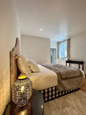 a bedroom with a bed and a table with a lamp at Stilias Apartment 4P Brussels City in Brussels