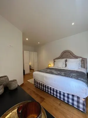 a bedroom with a large bed and a table at Stilias Apartment 4P Brussels City in Brussels
