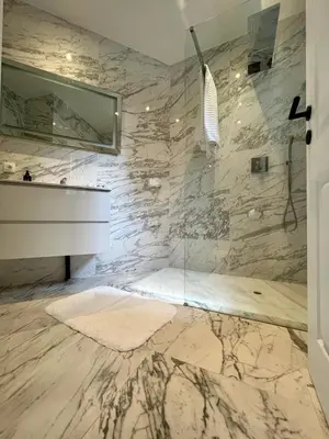 a bathroom with a sink and a marble wall at Stilias Apartment 4P Brussels City in Brussels