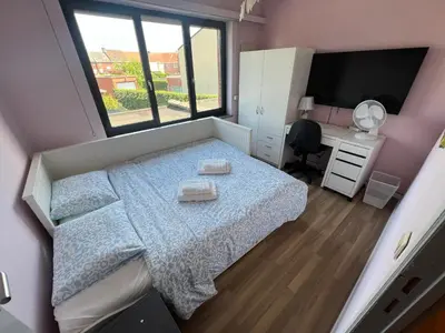 a bedroom with a bed and a desk and a television at Rooms for Tomorrowland 2026 in Boom