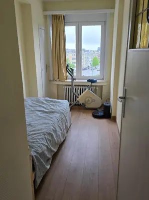 a bedroom with a bed and a treadmill in front of a window at Luxurious 4 in Brussels