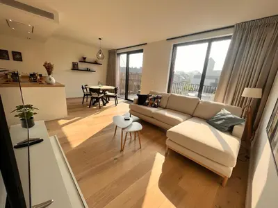 a living room with a couch and a table at Casa Matti - Modern Apartment with Garden View and Terrace in Ghent