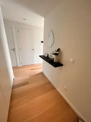 a room with a hallway with a mirror and a wooden floor at Casa Matti - Modern Apartment with Garden View and Terrace in Ghent