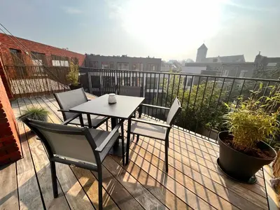 a patio with a table and chairs on a balcony at Casa Matti - Modern Apartment with Garden View and Terrace in Ghent