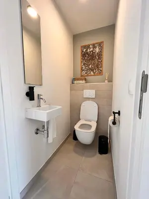 a bathroom with a toilet and a sink at Casa Matti - Modern Apartment with Garden View and Terrace in Ghent