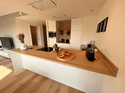 a kitchen with a wooden counter top in a room at Casa Matti - Modern Apartment with Garden View and Terrace in Ghent