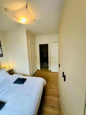 a bedroom with a large white bed and a hallway at Urbanstay Suites - Jacqmain Downtown Suite in Brussels