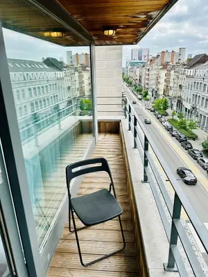 a chair sitting on the balcony of a building at Urbanstay Suites - Jacqmain Downtown Suite in Brussels
