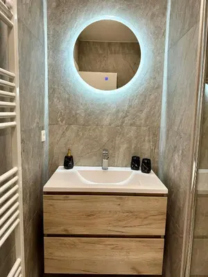 a bathroom with a sink and a round mirror at Urbanstay Suites - Jacqmain Downtown Suite in Brussels
