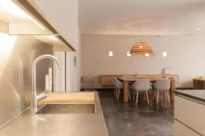 a kitchen and dining room with a dining table at Casa Tintos in Sint-Amands