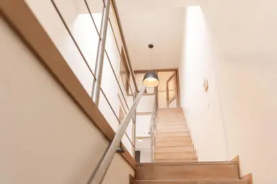 a staircase in a house with wooden floors and a lamp at Casa Tintos in Sint-Amands
