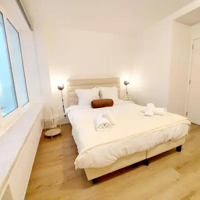 a bedroom with a large white bed with two lamps at New Luxe Grand place Apartment in Brussels