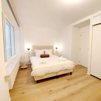a white bedroom with a large bed in a room at New Luxe Grand place Apartment in Brussels