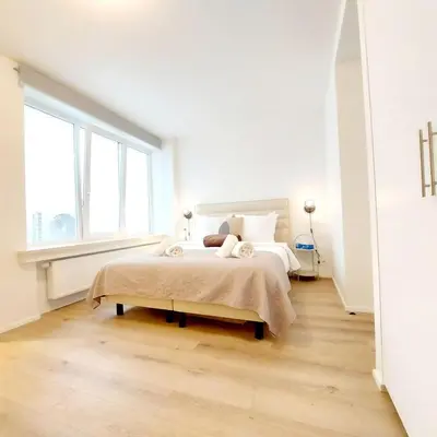 a white bedroom with a bed and a window at New Luxe Grand place Apartment in Brussels