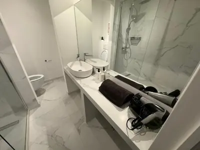 a white bathroom with a sink and a shower at Two bedroom loft in the city center by the Meir in Antwerp