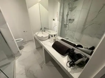 a white bathroom with a sink and a shower at Two bedroom loft in the city center by the Meir in Antwerp