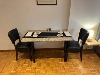 a table with black chairs and a tableasteryasteryasteryasteryasteryasteryasteryastery at Two bedroom loft in the city center by the Meir in Antwerp