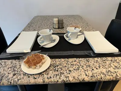 a table with two cups and a plate of food at Two bedroom loft in the city center by the Meir in Antwerp
