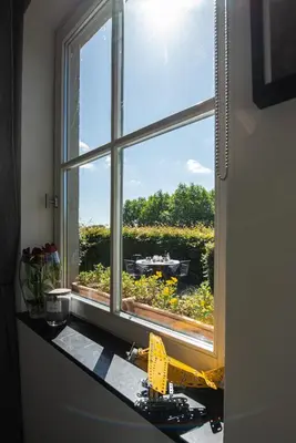 a window with a view of a field of flowers at B&B Art'Aviation in Beauvechain