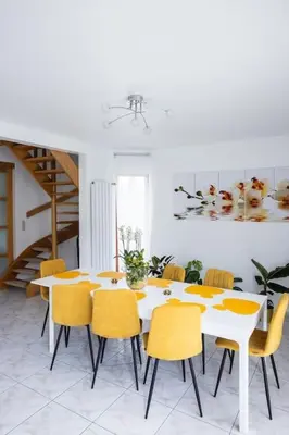 a dining room with a white table and yellow chairs at Résidence Orchidée in Zaventem