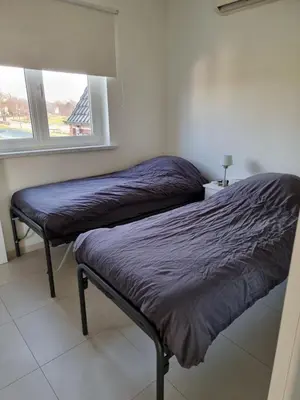 two beds in a room with a window at Guest House Scheldevallei in Merelbeke