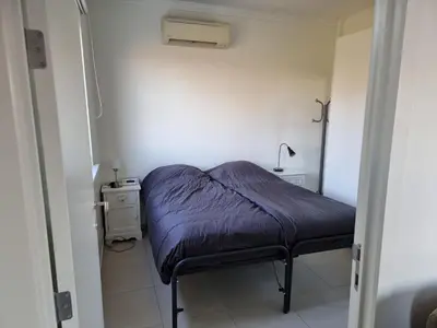 a small room with a bed and a lamp at Guest House Scheldevallei in Merelbeke