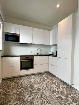 a kitchen with white cabinets and a tile floor at Stilias Apartment 6P City Center in Brussels