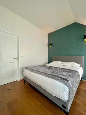a bedroom with a bed with a green accent wall at Stilias Apartment 6P City Center in Brussels