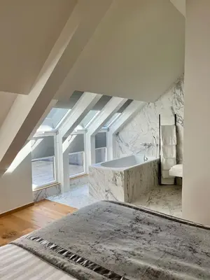 a bathroom with a large tub in the attic at Stilias Apartment 6P City Center in Brussels