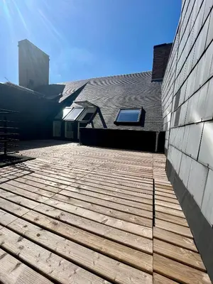 a building with a wooden deck next to a building at Stilias Apartment 6P City Center in Brussels