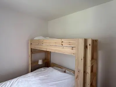 a wooden bunk bed in a room with a white bed at House of Legend in Antwerp
