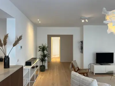 a white living room with a television and a living room at House of Legend in Antwerp