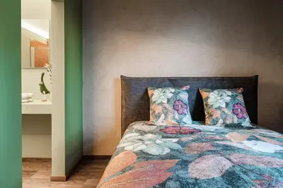 a bedroom with a bed with a colorful blanket and pillows at B&B CONVENT Begijnhof Herentals in Herentals