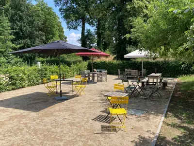 a group of tables and chairs with an umbrella at B&B CONVENT Begijnhof Herentals in Herentals