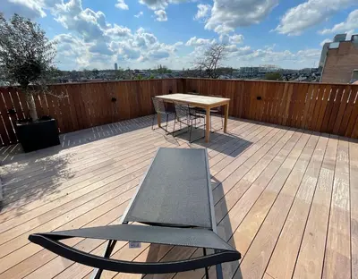 a table and a bench on a wooden deck at Penthouse with Airconditioning and Big Terrace, Close to Gent Sint-Pieters Station and City Centre in Ghent