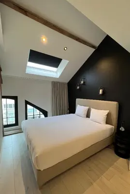 a bedroom with a large bed with a black wall at Penthouse with Airconditioning and Big Terrace, Close to Gent Sint-Pieters Station and City Centre in Ghent