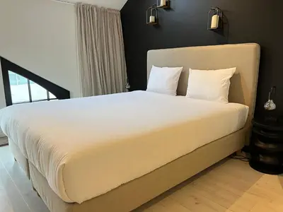 a bedroom with a large bed with white sheets at Penthouse with Airconditioning and Big Terrace, Close to Gent Sint-Pieters Station and City Centre in Ghent
